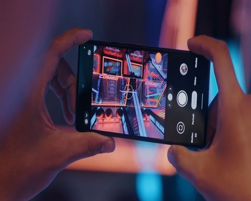 Mobile gaming demonstration shown on a central smartphone screen during a technology showcase